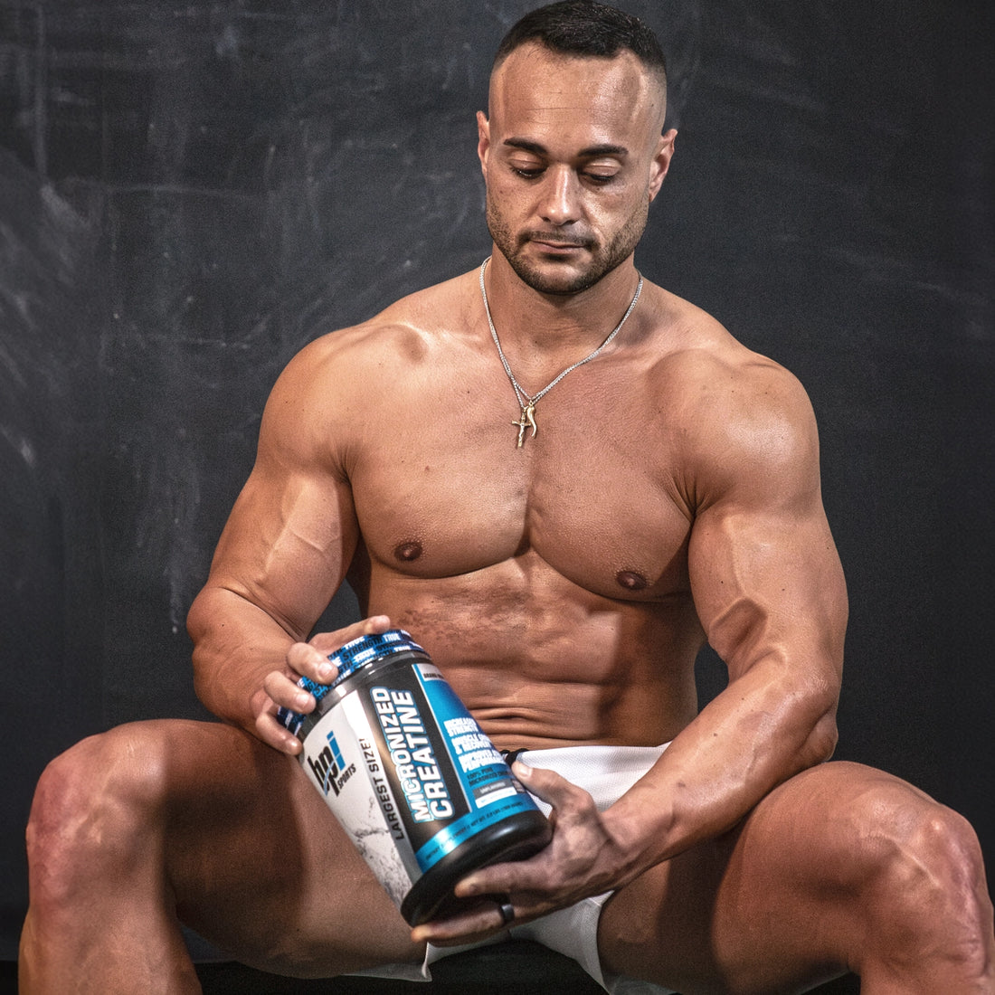 Atleta de BPI con un frasco de creatina micronizada